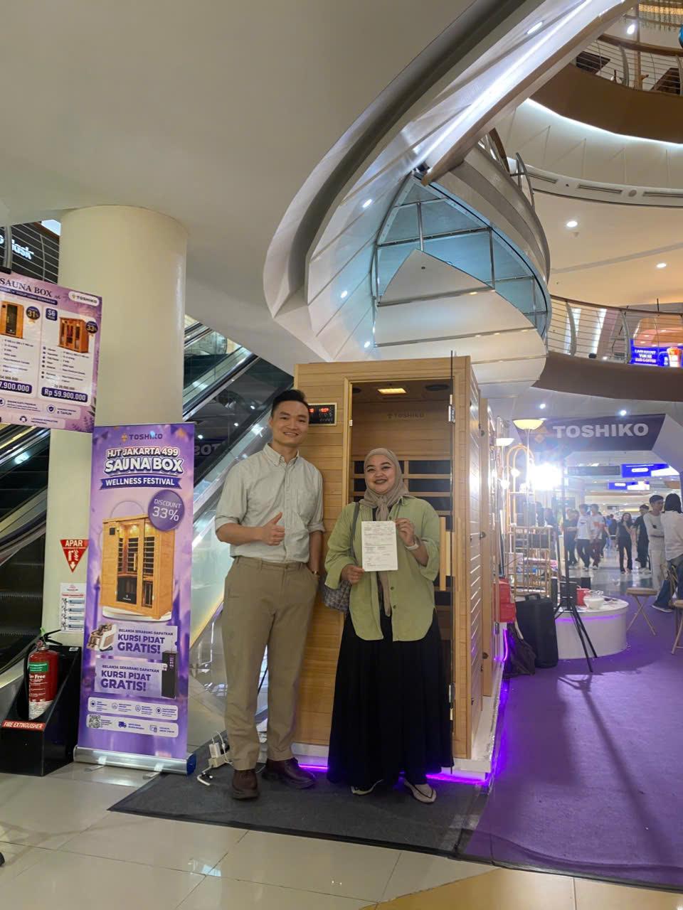 Toshiko staff handing over a sauna box order to a customer